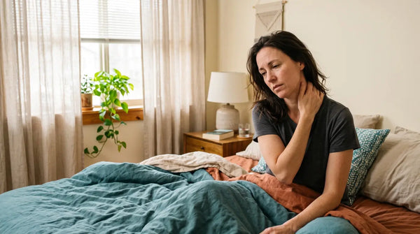 Mulher de meia idade na cama sentindo dor na cervical